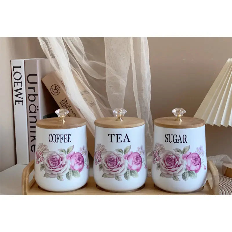 Floral-decorated ceramic canisters with wooden lids.