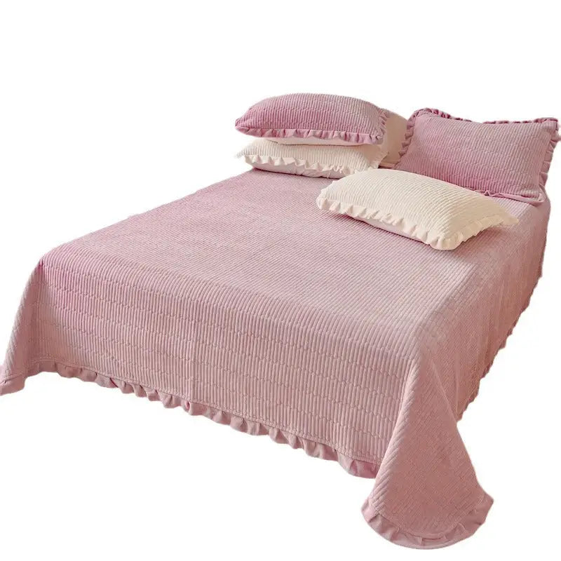Pink corduroy bedspread with ruffled edges and matching pillows.