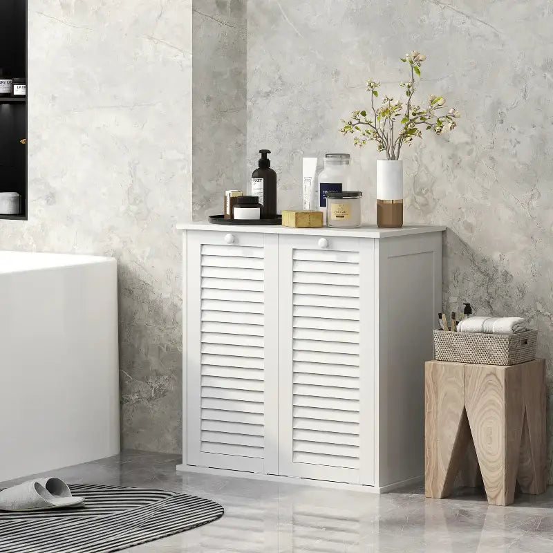 White bathroom cabinet with louvered doors.