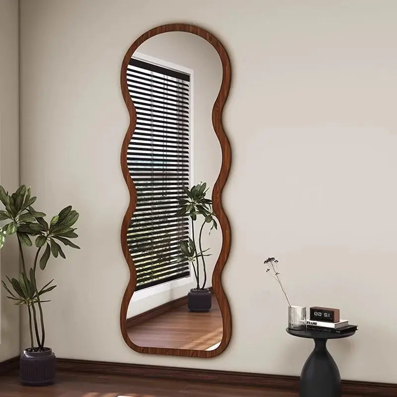 Wavy-edged full-length mirror with wood frame.