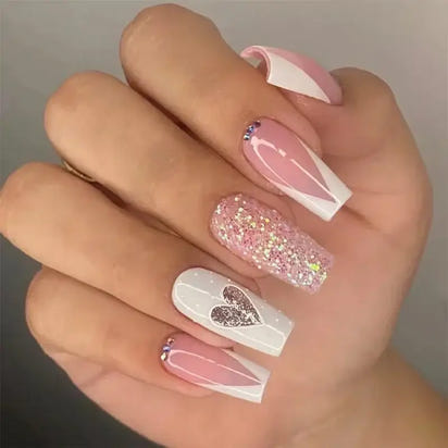 Manicured hand with Valentine’s Day-themed nail art.