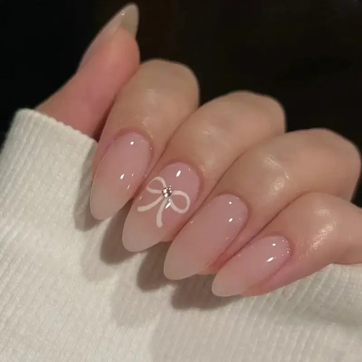 Elegant almond-shaped nails with a delicate bow design.