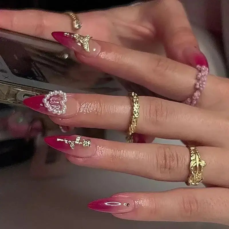 Elaborate, red-tipped manicure with rings.