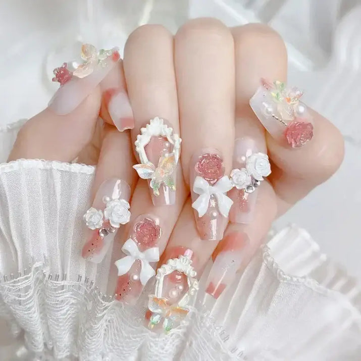 Elaborate nail art with floral and bow embellishments.