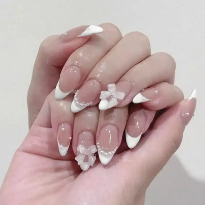 Elegant French manicure with bow accents.