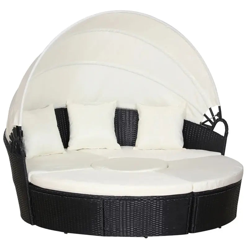 Round patio daybed with black wicker, white cushions, and canopy for outdoor lounging