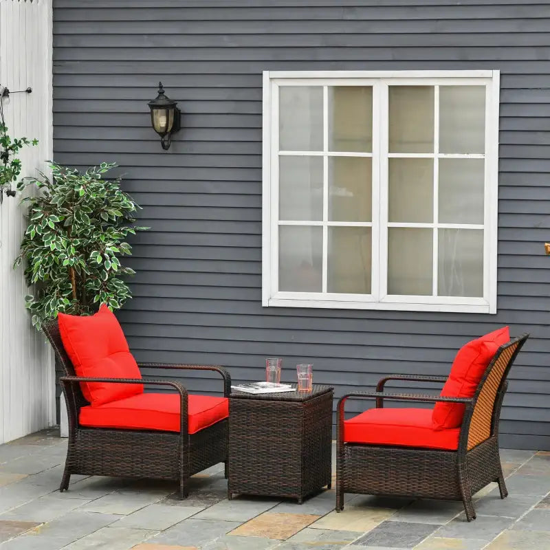 Wicker patio furniture set with red cushions.