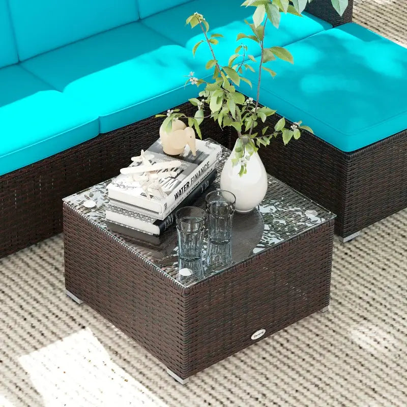 Wicker coffee table with glass top for patio furniture and three-seat sofa setup