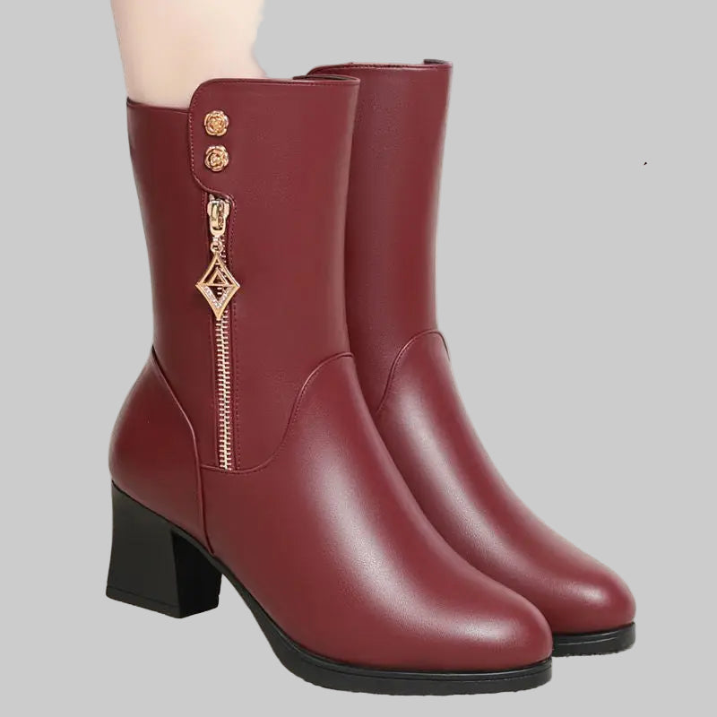 Pair of maroon boots with decorative elements on a gray background