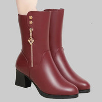 Pair of maroon boots with decorative elements on a gray background