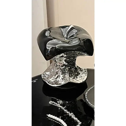 Black and silver decorative object on a reflective surface
