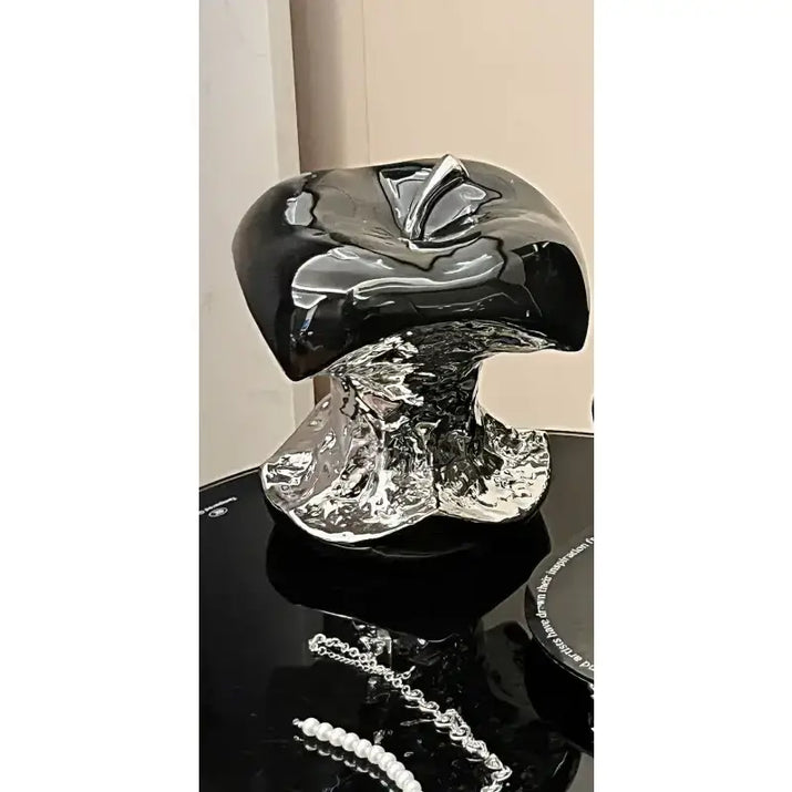 Black and silver decorative object on a reflective surface