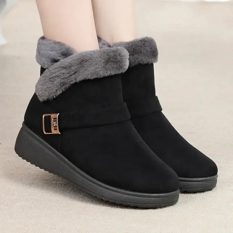 Black winter boots with gray fur trim on a neutral background