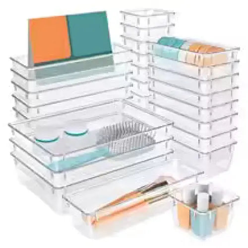 Clear plastic desk organizer with various compartments and stationery items on a white background