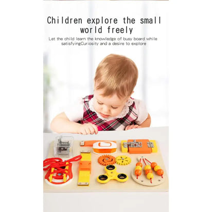 Child playing with a busy board filled with various educational toys on a white surface.