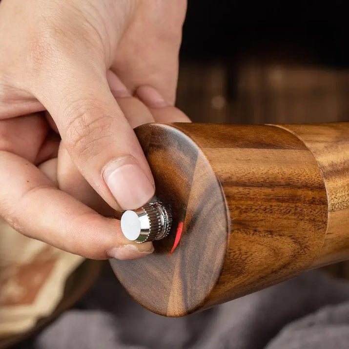 Wooden pepper grinder with silver knob.