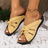 Beige leather sandals with bow detail.