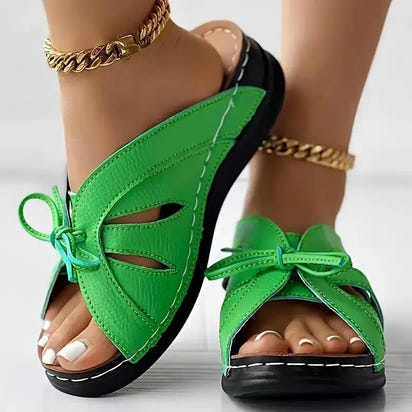 Green leather sandals with ankle bracelets.