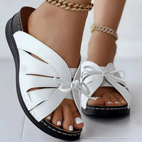White leather sandals with black soles.