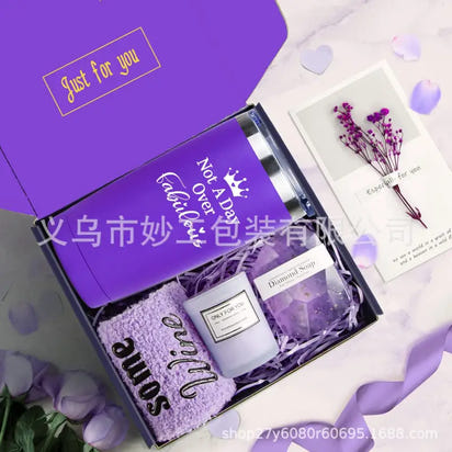 Purple gift box with tumbler, candle, soap, and towel.