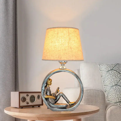 Figurine lamp with a circular base.