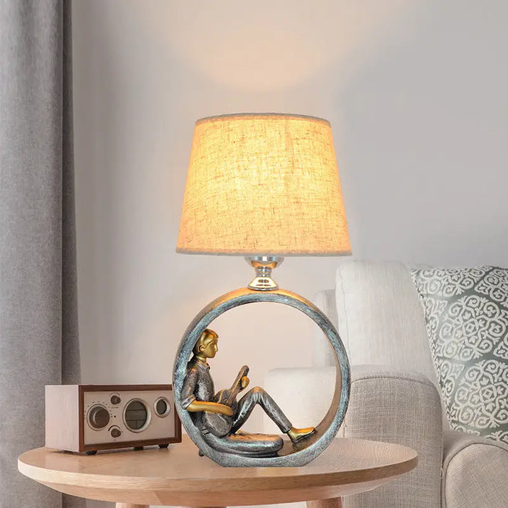 Figurine lamp with a circular base.