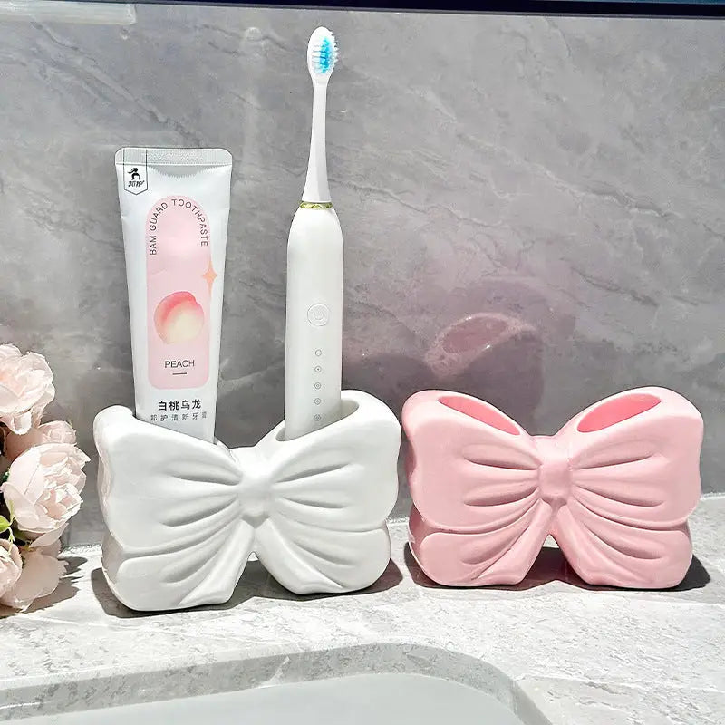 Bow-shaped toothbrush and toothpaste holders.