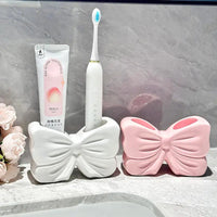 Bow-shaped toothbrush and toothpaste holders.