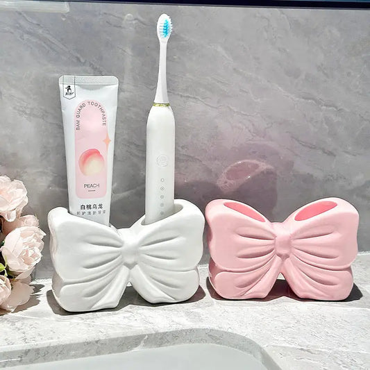 Bow-shaped toothbrush and toothpaste holders.