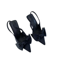 Pair of black slingback heels with bows.