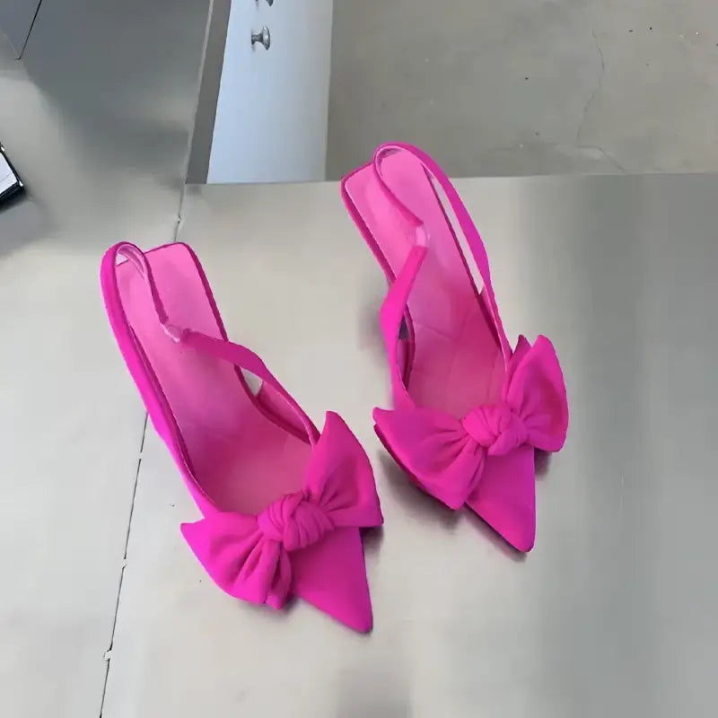 Pair of pink bow-adorned slingback heels.