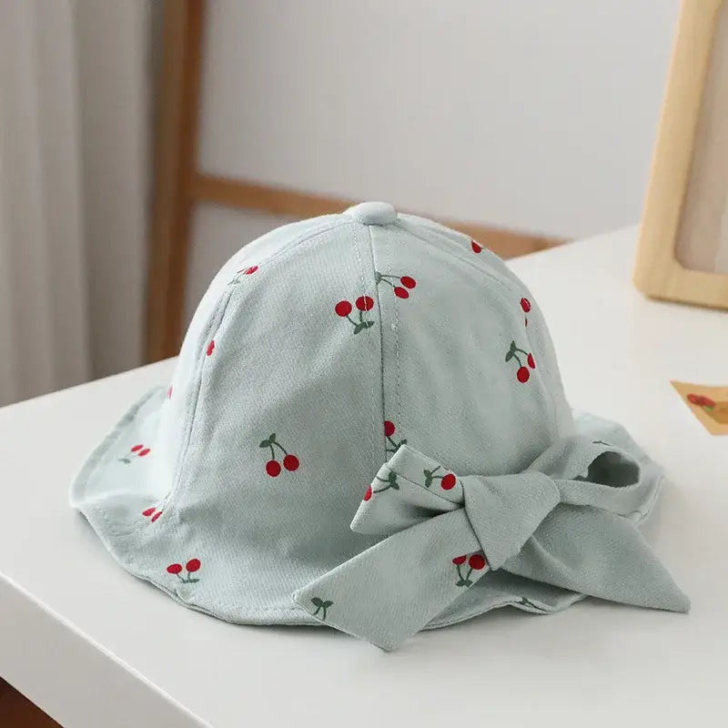 Light blue cherry-patterned sun hat with bow.