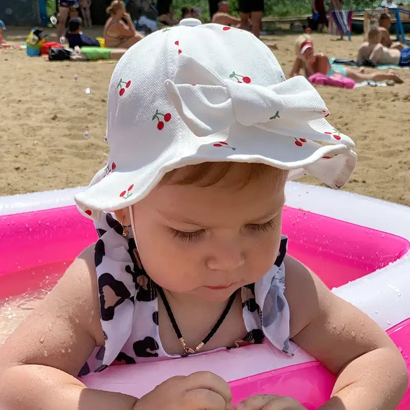 Baby in cherry-patterned sun hat.