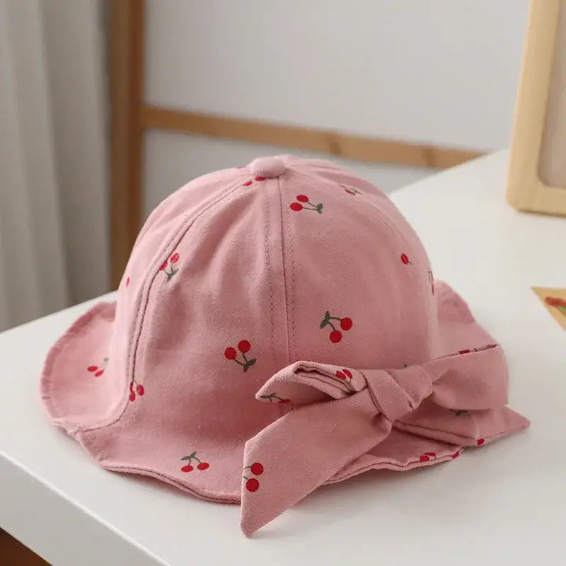 Pink cherry-patterned sun hat with bow.