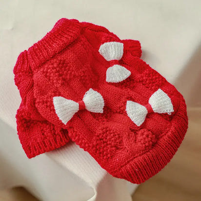 Red knitted dog sweater with white bows.