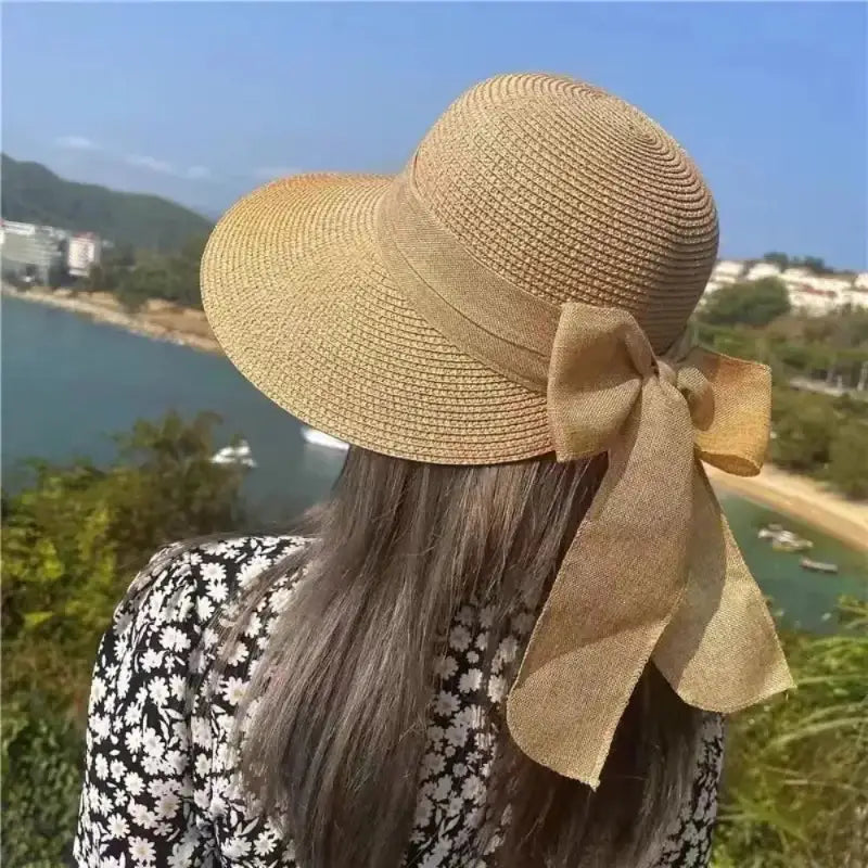 Tan straw sunhat with bow.