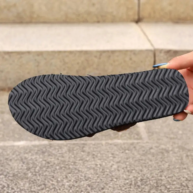 Black sandal sole with wavy tread.