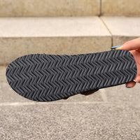 Black sandal sole with wavy tread.
