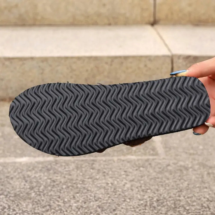 Black sandal sole with wavy tread.