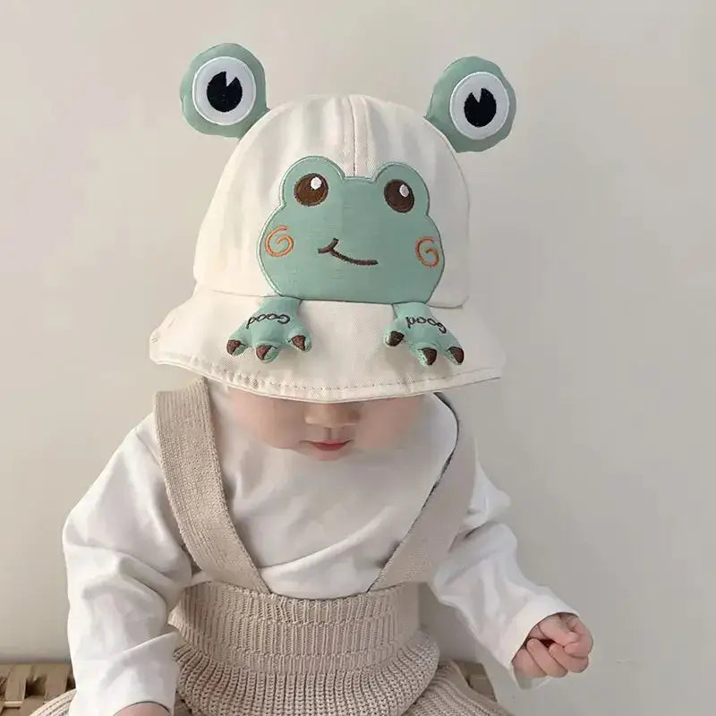 Baby wearing a frog hat.