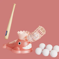 Pink whale-shaped baseball pitching machine with bat and balls.