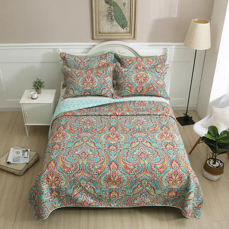 Patterned bedspread with matching pillows.
