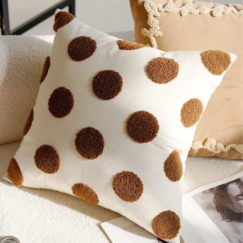White pillow with brown polka dots.