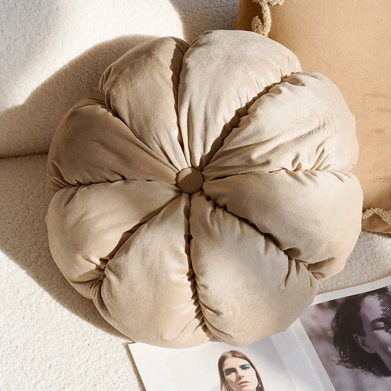 Beige, plush, pumpkin-shaped pillow.