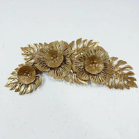 Gold-colored metal floral wall decor.