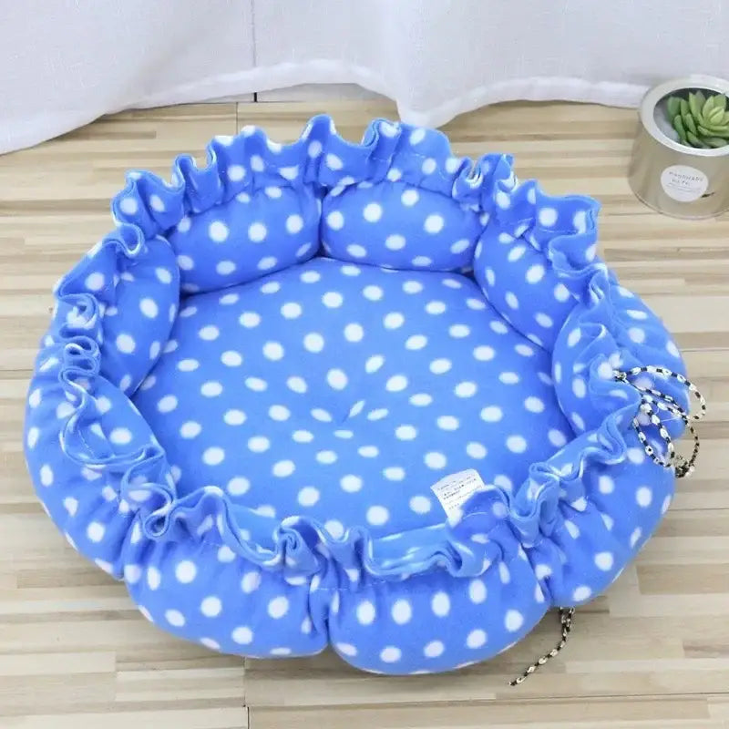 Blue polka-dotted pet bed with ruffled edges.