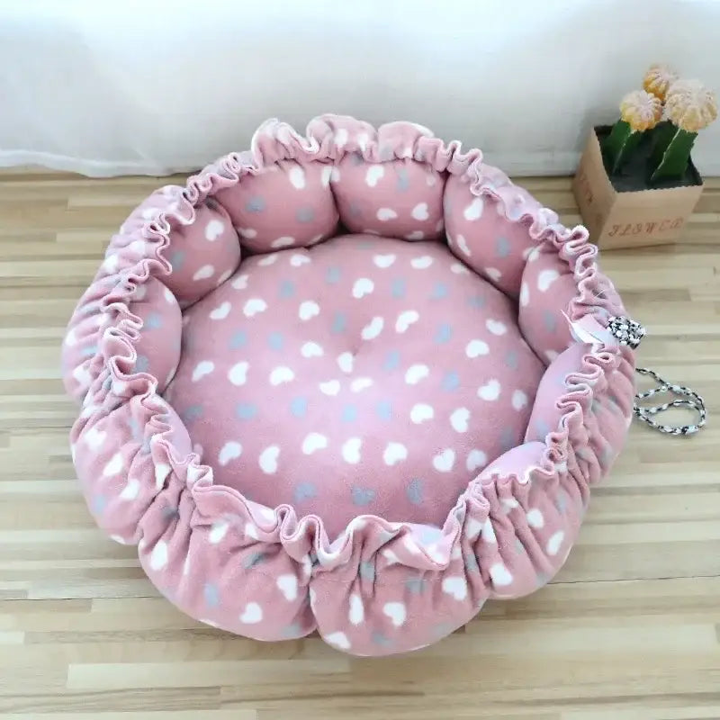 Pink, heart-patterned, ruffled pet bed.