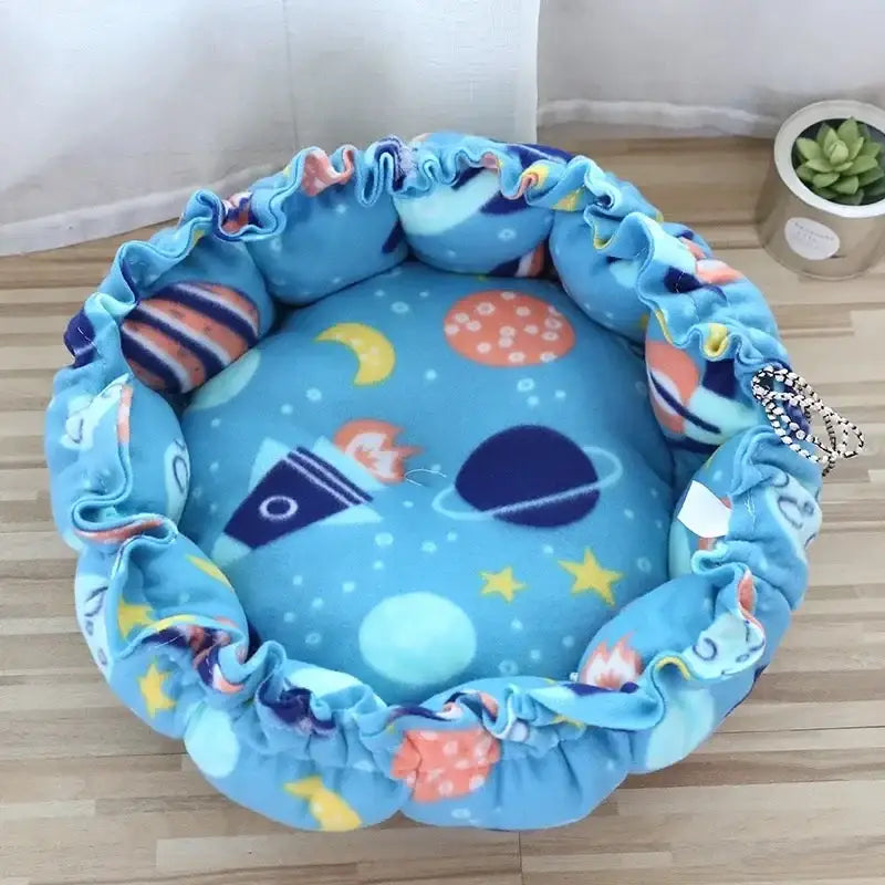 Round, blue, space-themed pet bed.