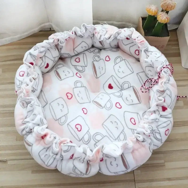 Round pet bed with mug pattern.