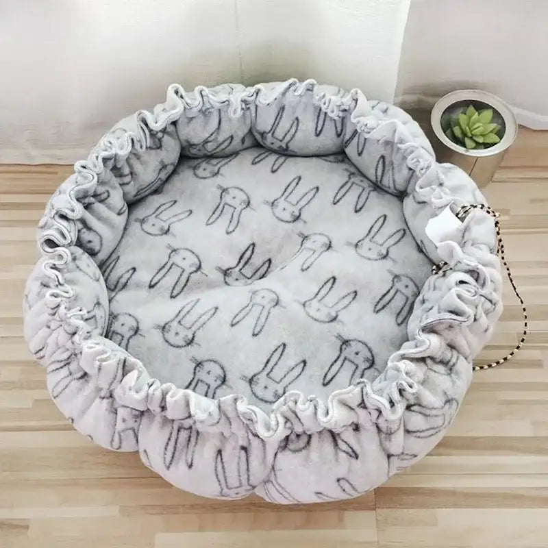 Round pet bed with bunny pattern.